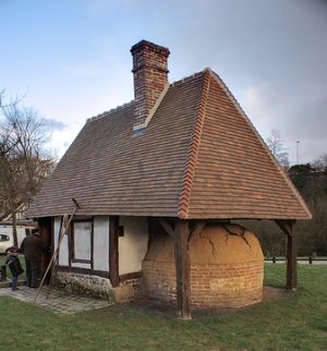 brick oven extends under eaves of bakehouse